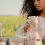 A/B Testing - Young Woman in Airy Summer Dress Creating Perfumes in Flower Field Laboratory